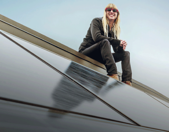 Frau auf Dach mit Solarpanelen