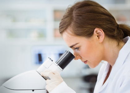 Eine Frau schaut in ein Mikroskop